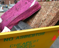 Old mattresses in a yellow skip